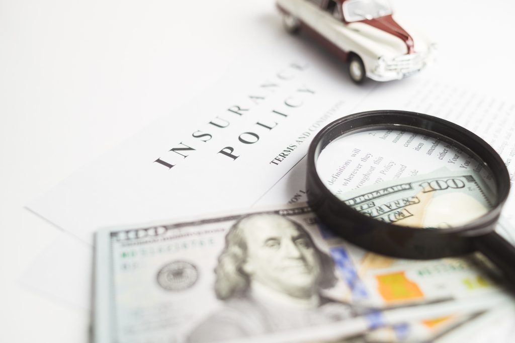 Certificate of motor insurance and policy with car and dollar bills